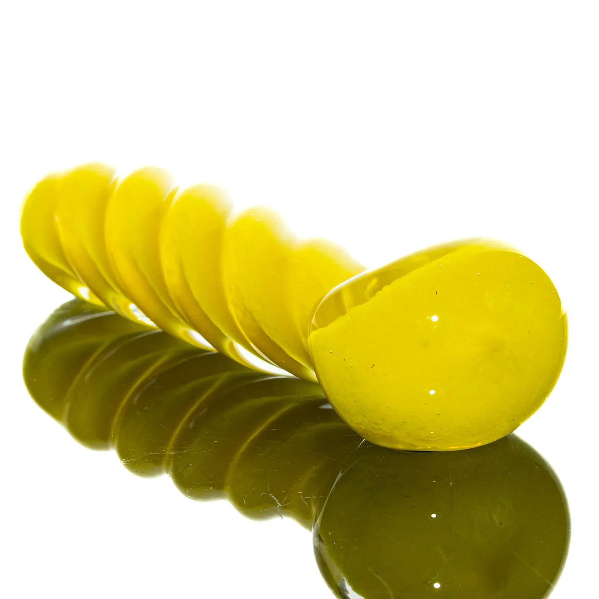 Yellow glass twist spoon pipe with reflective base on white background