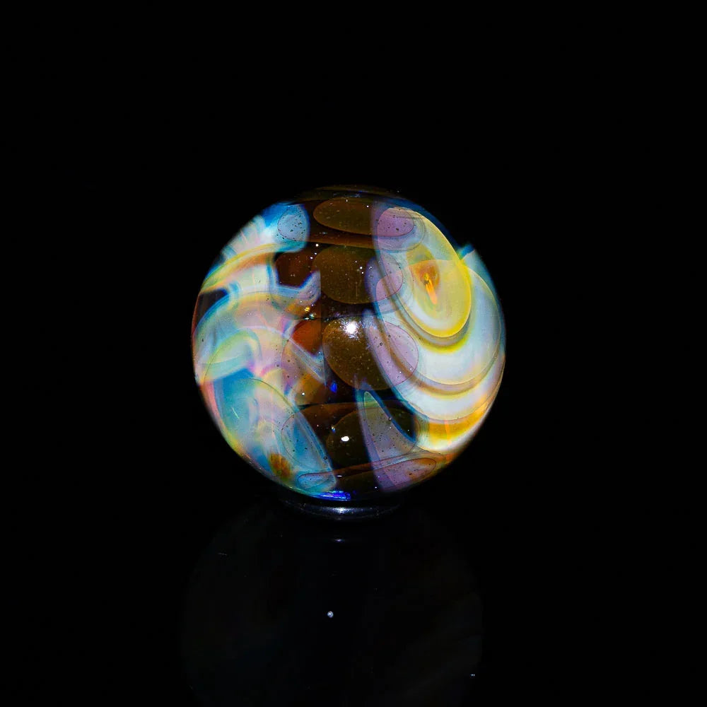 Colorful heady glass marble with swirling patterns on a black background