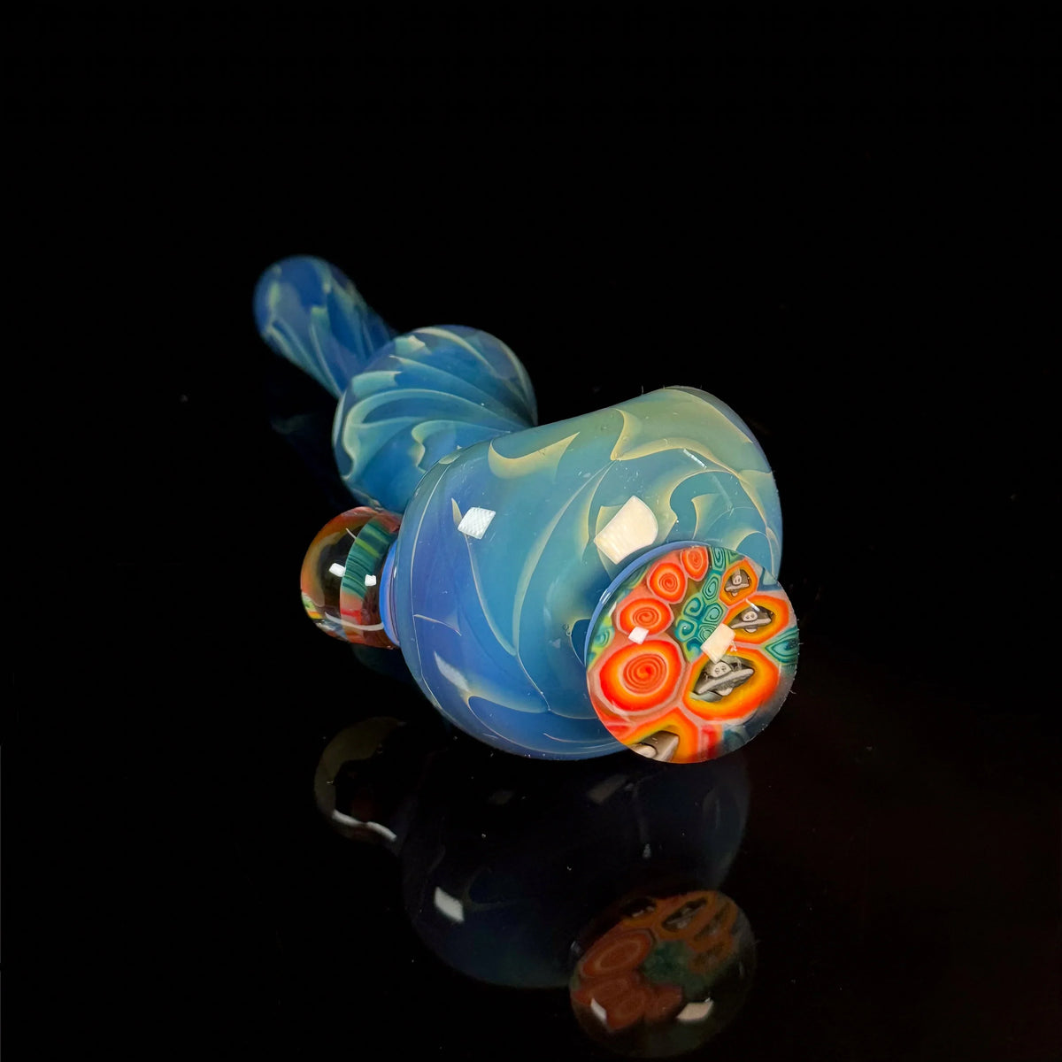 Blue hand-blown glass pipe with colorful decorative accents on a black background