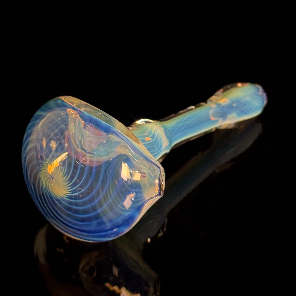 Hand-blown glass pipe with blue and yellow swirls on a black background