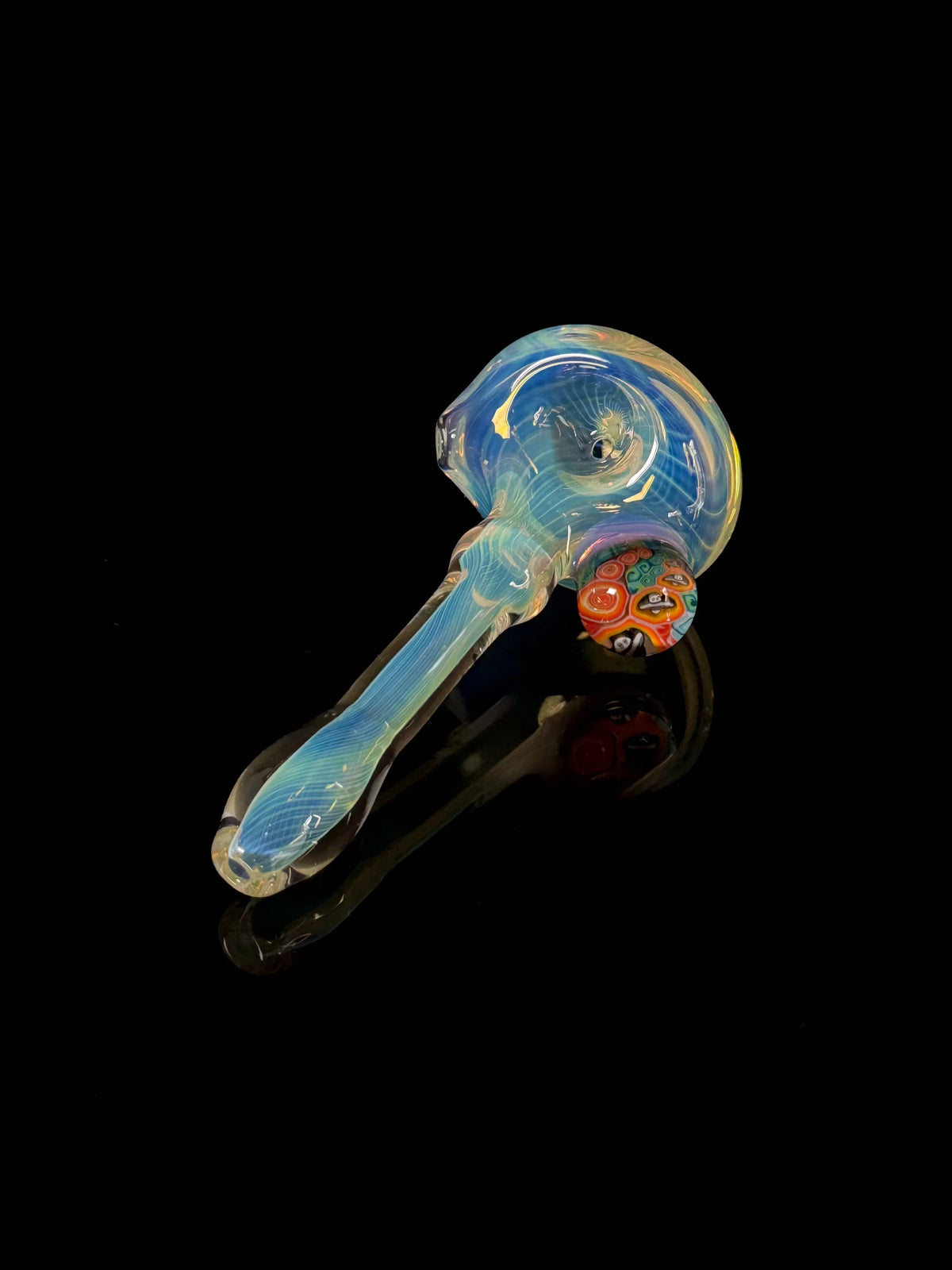 Colorful heady glass hand pipe with swirl and millefiori detail on a black background