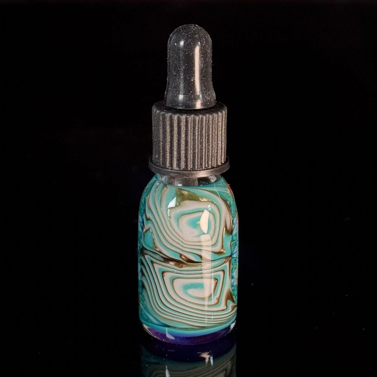 Colorful swirl glass dropper bottle with black cap on black background