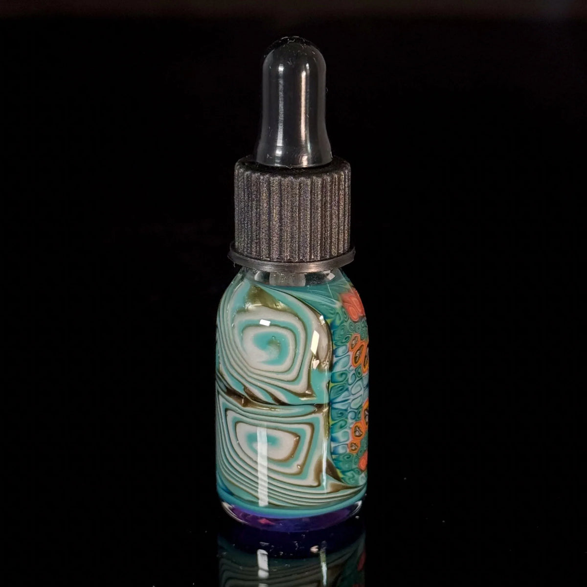 Colorful glass dropper bottle with abstract swirling patterns on a black background
