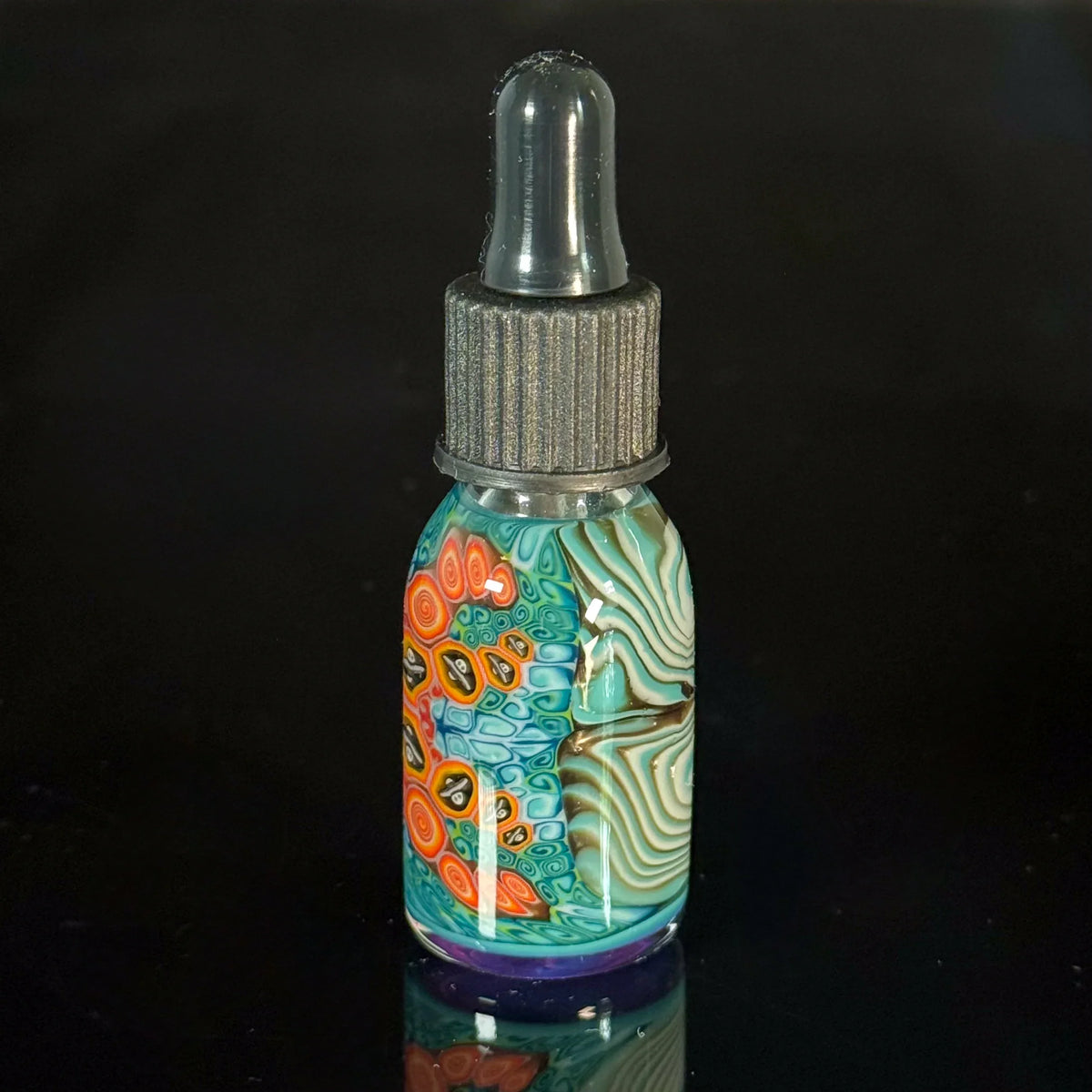 Handcrafted glass dropper bottle with colorful psychedelic patterns on black background