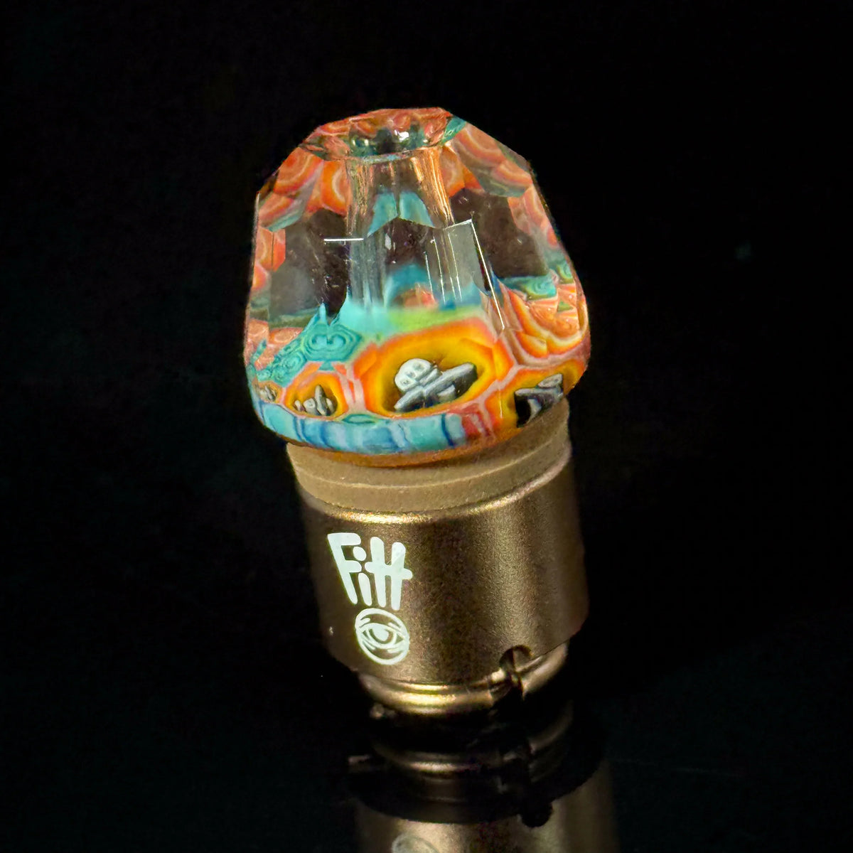 Colorful heady glass carb cap with intricate design on a metallic vaporizer accessory base