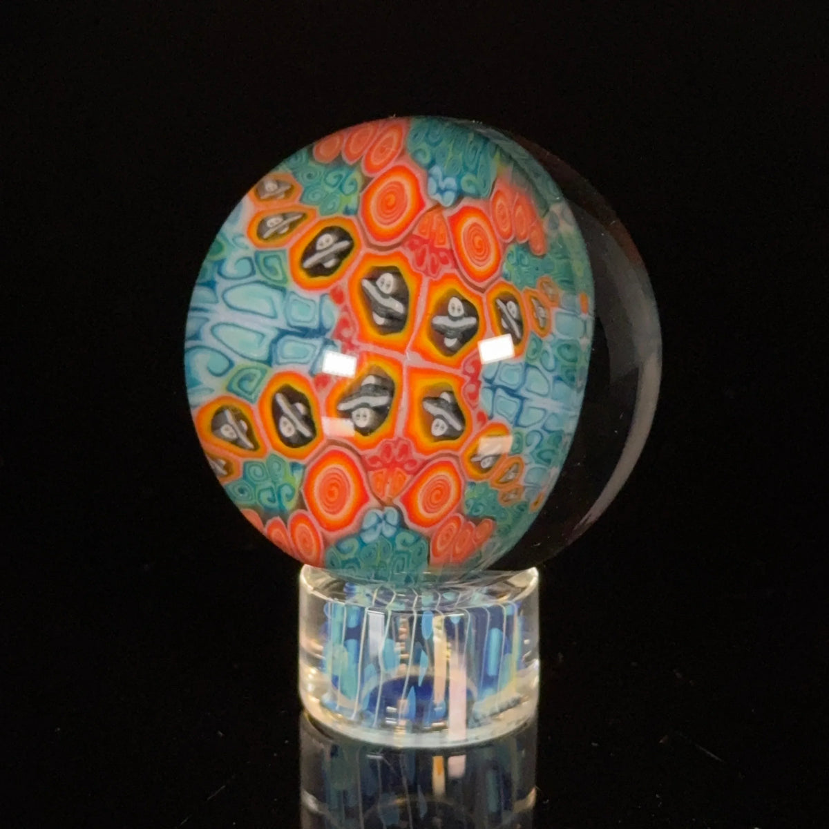 Colorful heady glass marble with intricate swirl and skull designs on black background