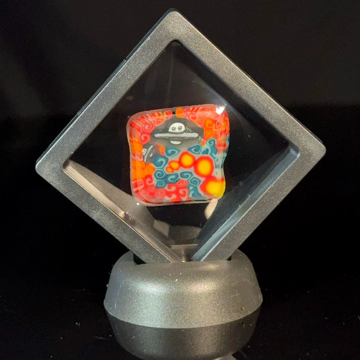 Colorful heady glass pendant with UFO and alien design in a display case