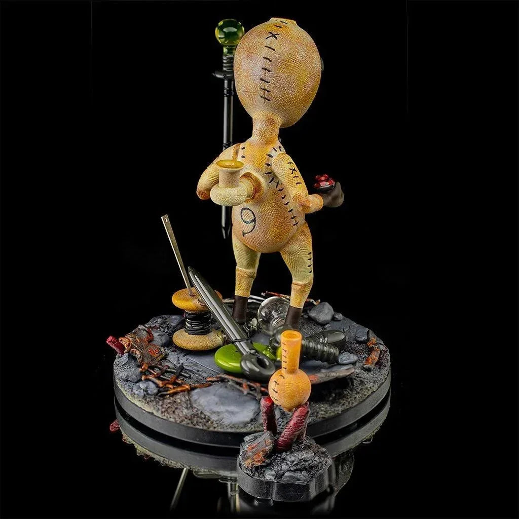 Handcrafted glass art figure resembling a stitched doll on detailed display base.
