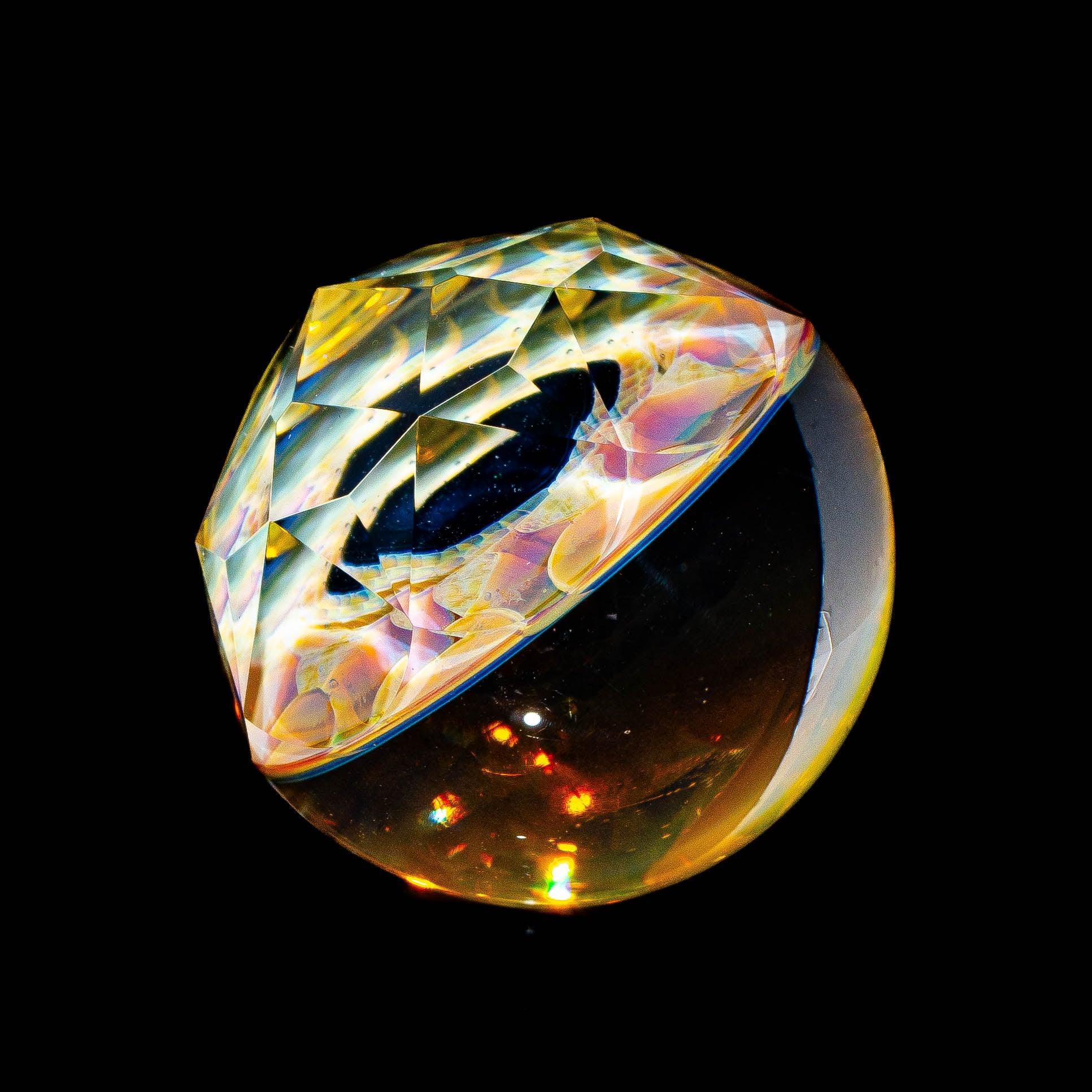 Colorful faceted glass marble with intricate patterns on a black background