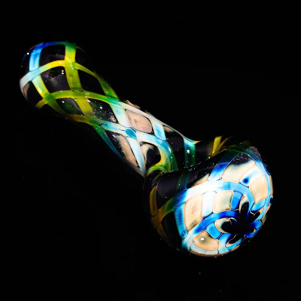 Hand-blown glass spoon pipe with black, blue, and green crosshatch pattern on black background