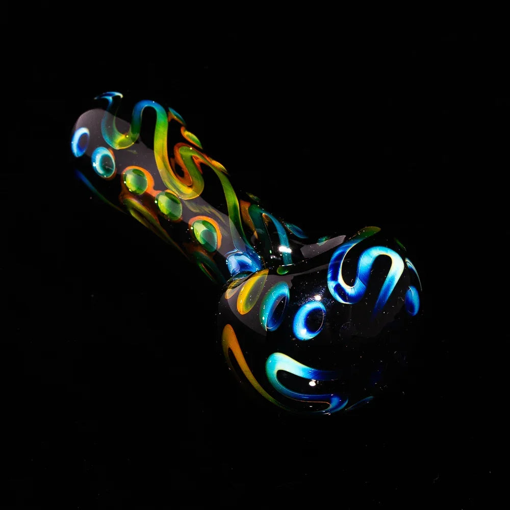 Black glass spoon pipe with colorful swirl and dot patterns on a black background