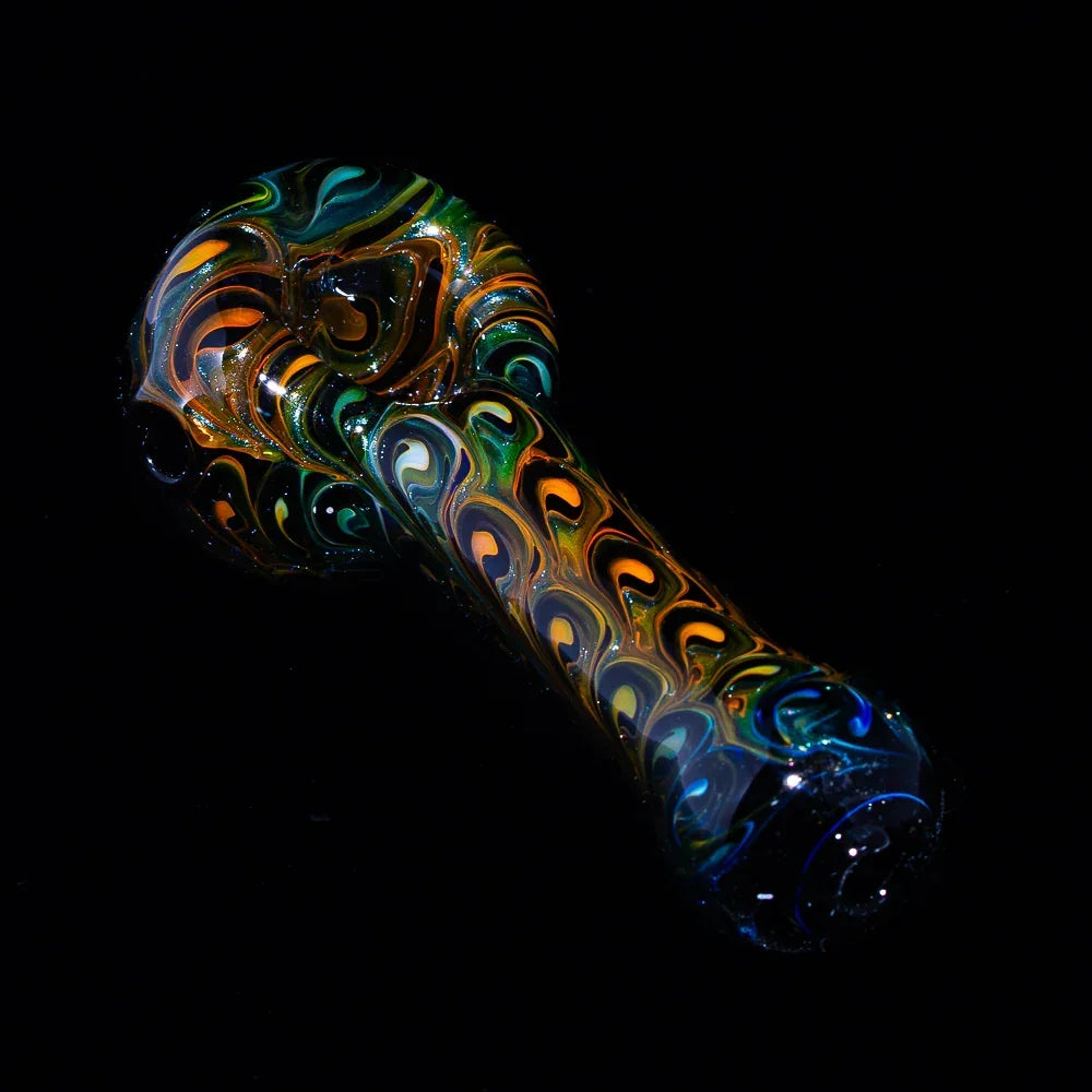 Colorful hand-blown glass spoon pipe with swirling peacock feather pattern on black background