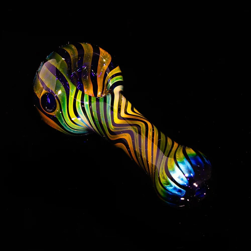 Blue and orange fumed glass spoon pipe with intricate linework design on a black background.