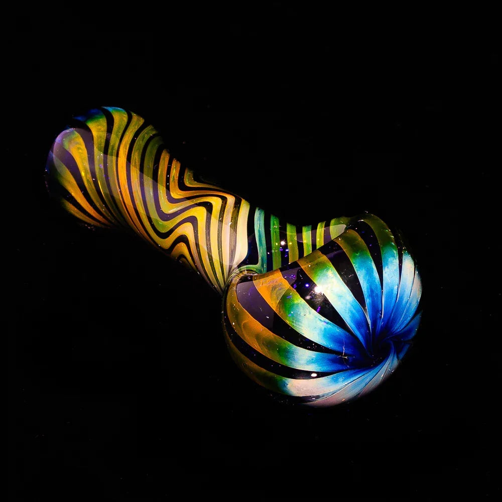 Blue fumed glass spoon pipe with vibrant linework on a black background