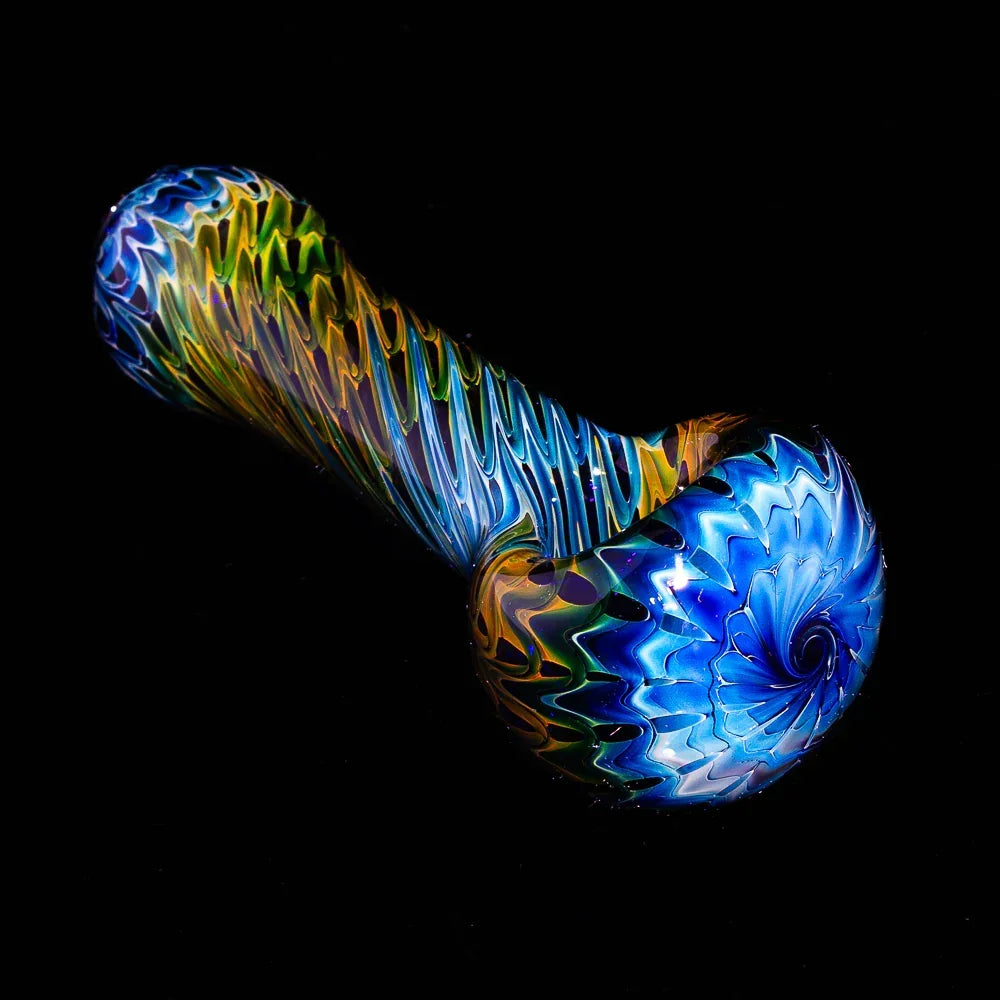 Colorful glass spoon pipe with blue raked swirl design on black background