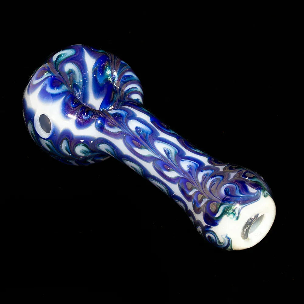Blue and white paisley glass hand pipe with intricate swirling pattern on black background