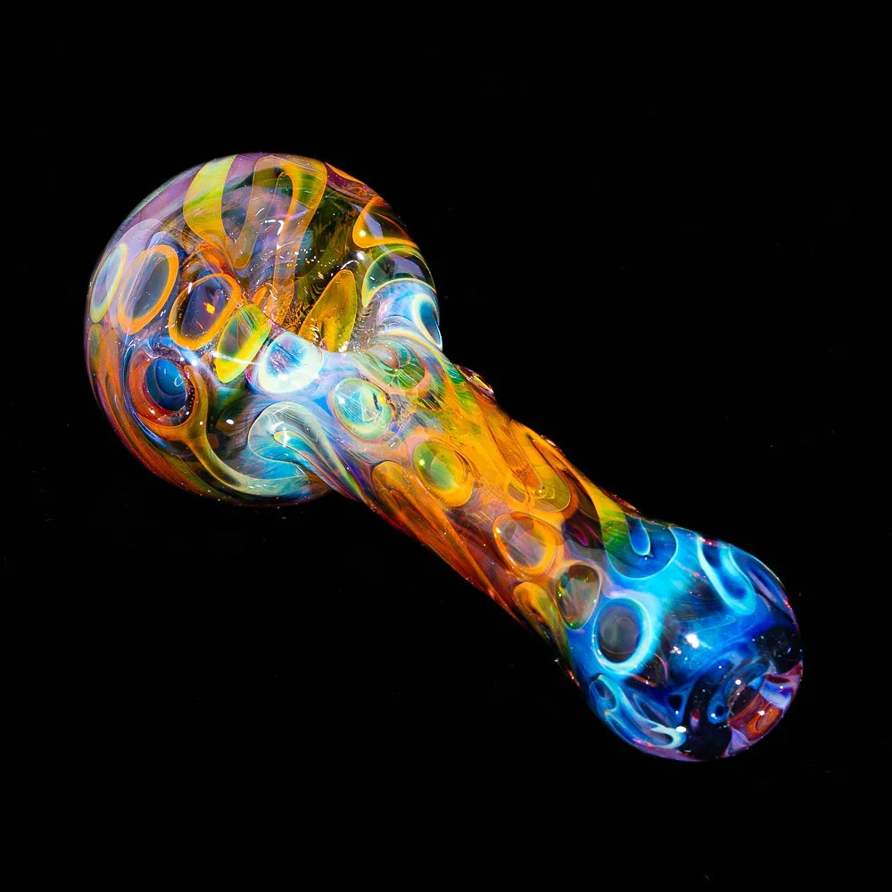 Colorful fumed glass spoon pipe with vibrant swirling patterns on a black background