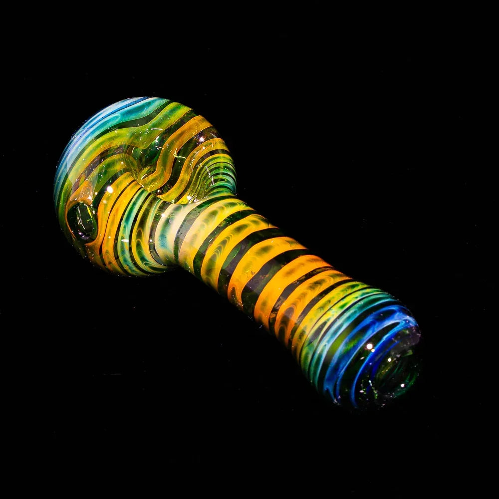 Colorful green fumed glass hand pipe with vibrant coil patterns on a black background