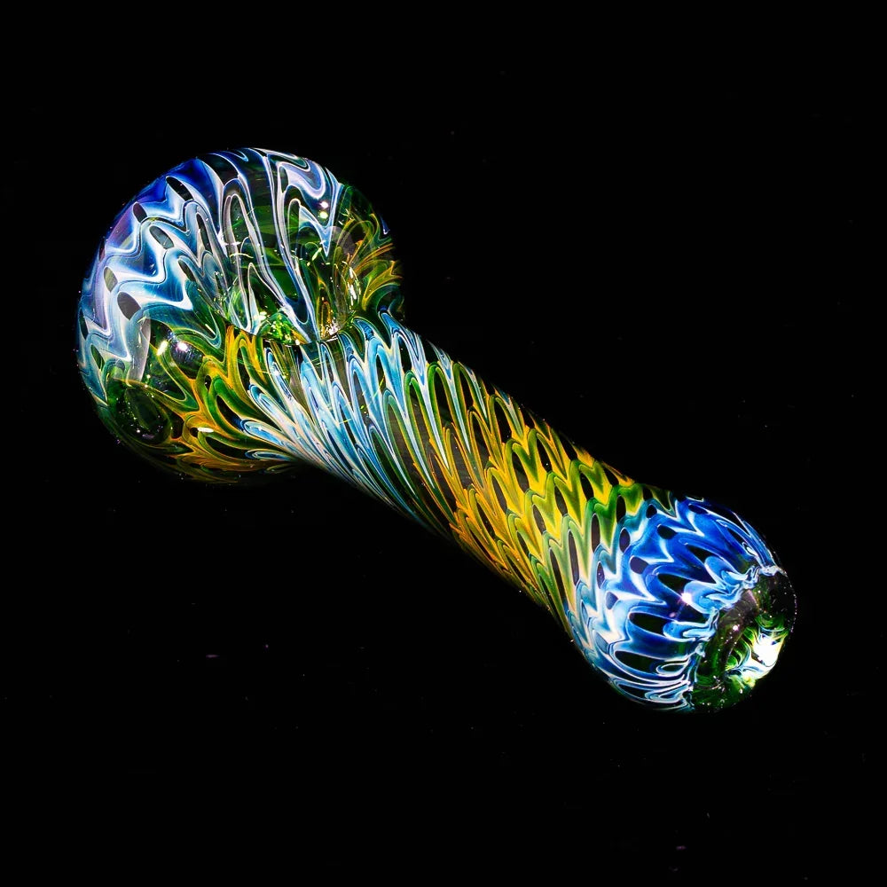 Colorful raked fume glass spoon pipe with green, blue, and yellow patterns on black background