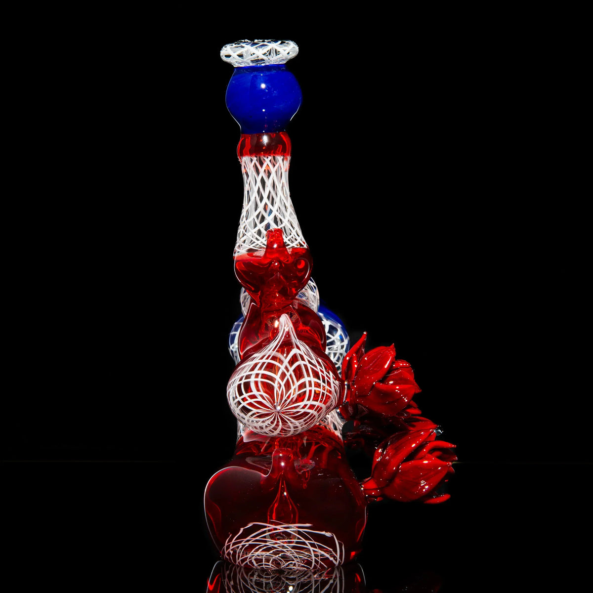 Hand-blown red, white, and blue glass water pipe with intricate pattern and floral accents