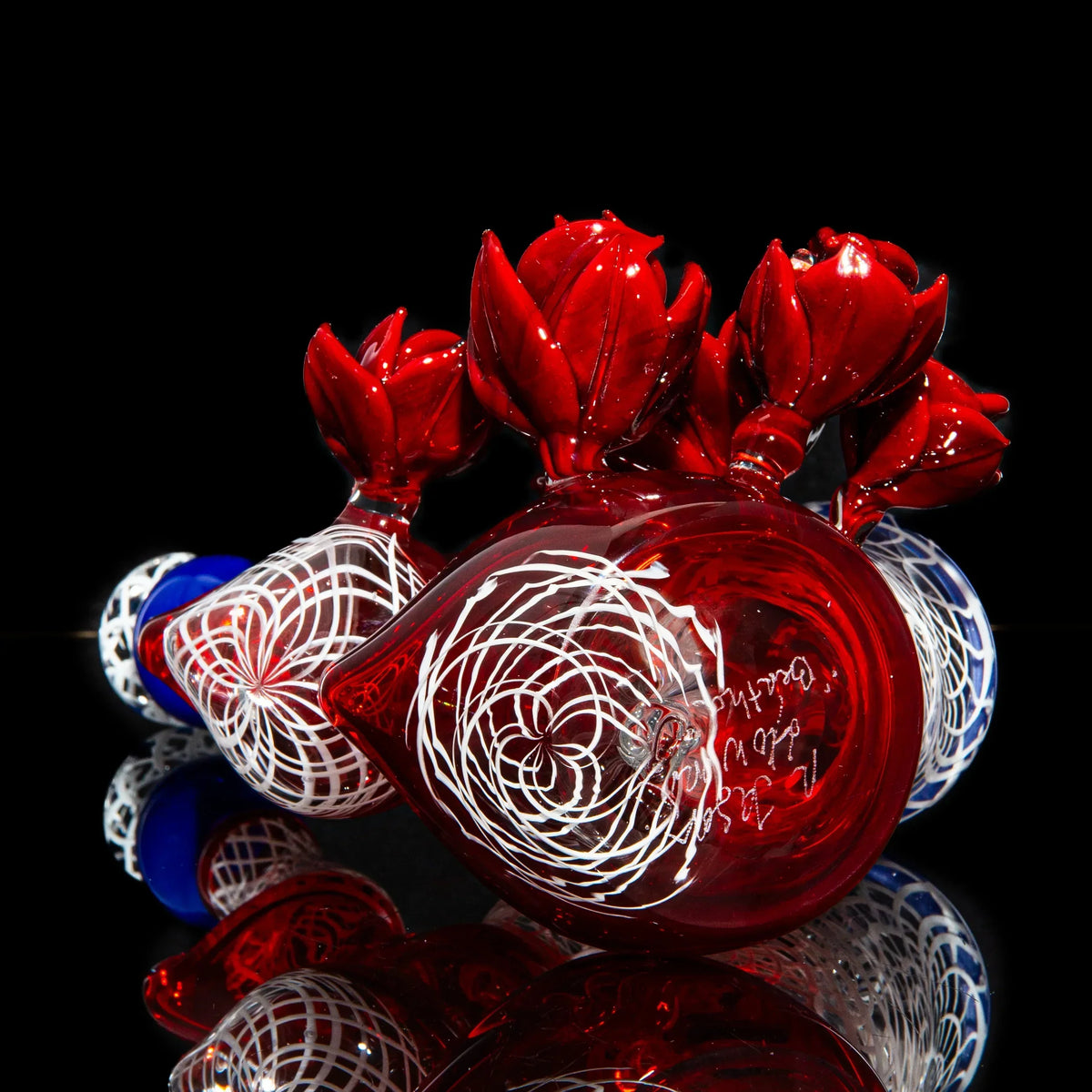 Red and blue double bubbler glass pipe with intricate white swirl patterns and floral accents