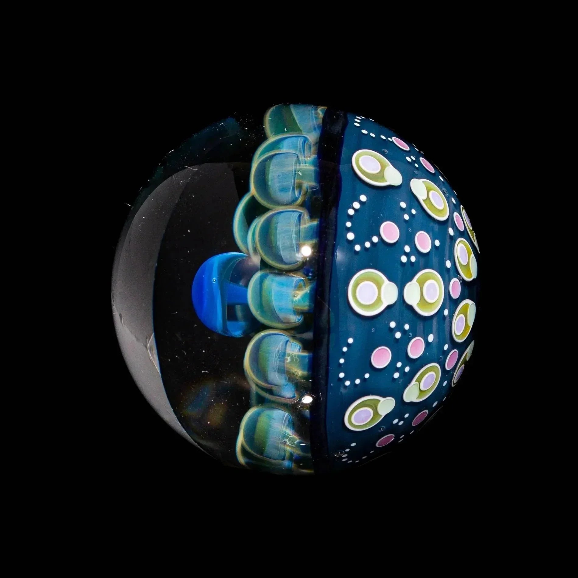 Blue glass marble with intricate mushroom design and colorful dotted patterns on black background