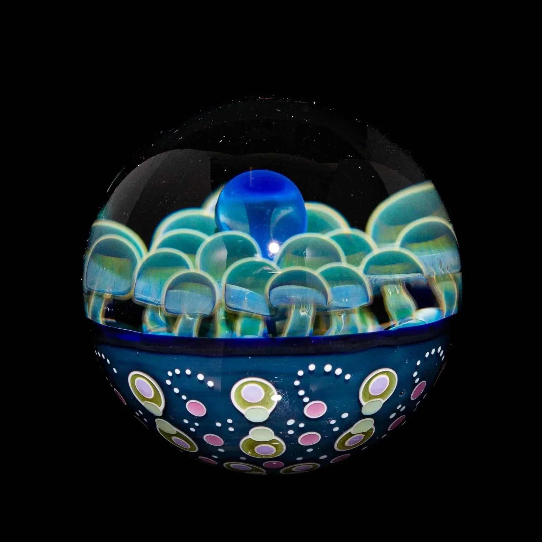 Hand-blown glass marble with blue and green mushroom design and colorful dotted accents