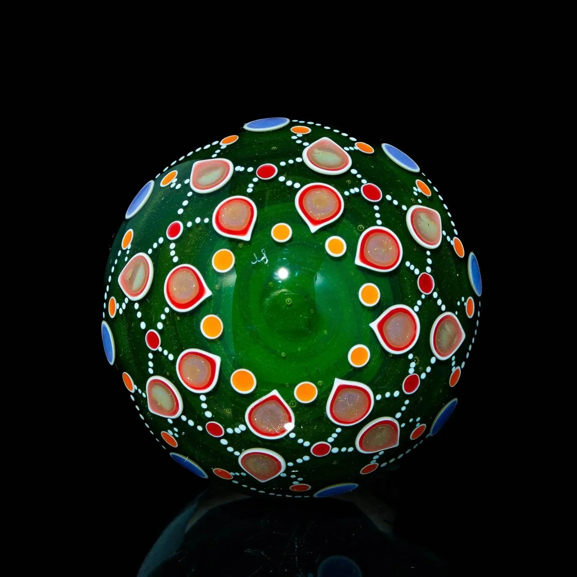 Green reticello glass marble with colorful dot and pattern accents on black background