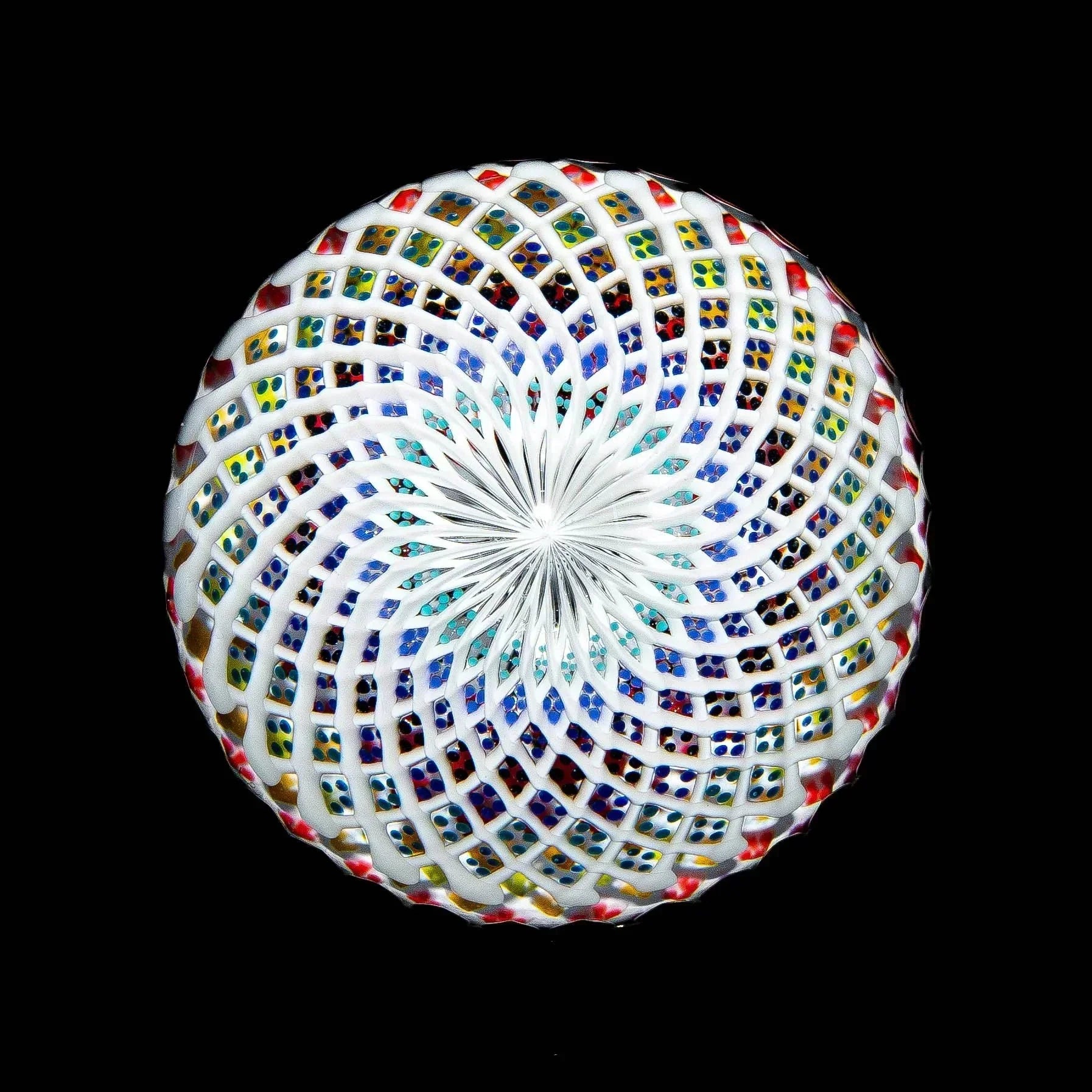 Intricate hand-blown glass marble with colorful lattice and spiral pattern on black background