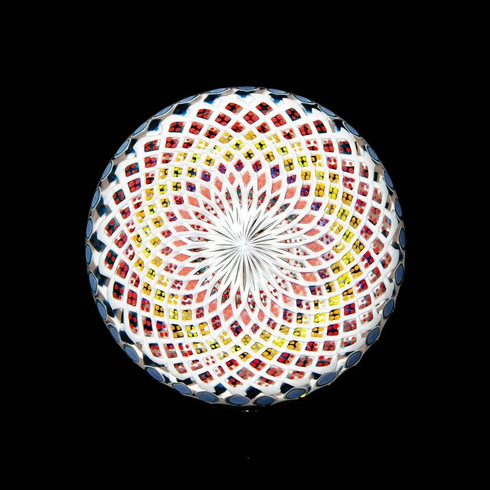 Intricate heady glass marble with colorful geometric dot and line patterns on black background