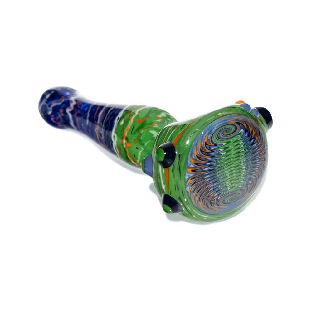 Hand-blown glass pipe with green, navy, and orange wig wag patterns on white background