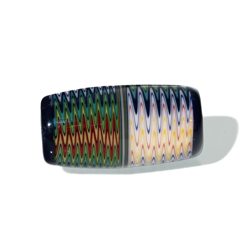 Rectangular navy wig wag glass bead with vibrant zigzag pattern, photographed on white background