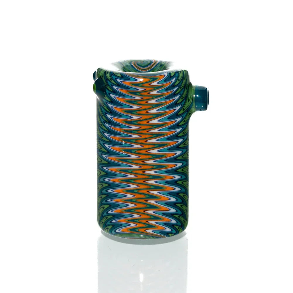 Colorful glass hand pipe with teal, orange, and blue zigzag wig wag pattern on white background