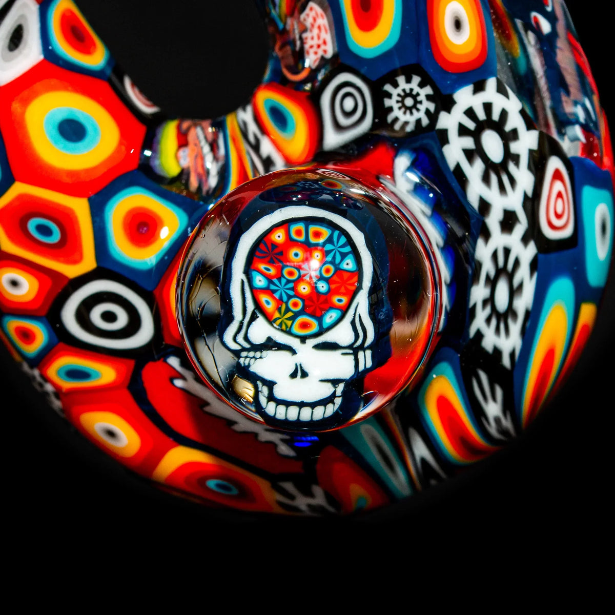 Colorful heady glass art piece with intricate skull design and vibrant patterns