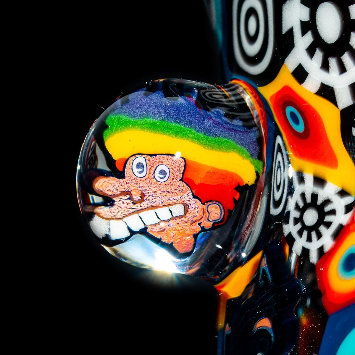Close-up of colorful heady glass pipe with psychedelic face and geometric designs