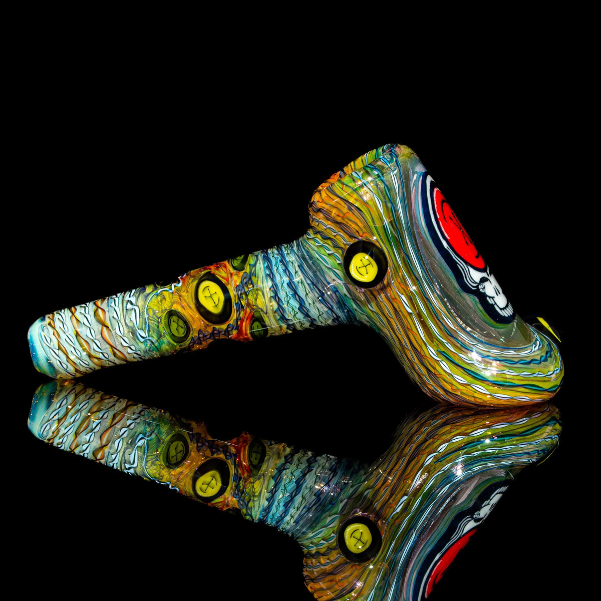 Colorful hand-blown glass pipe with vibrant patterns and unique design accents on black background.