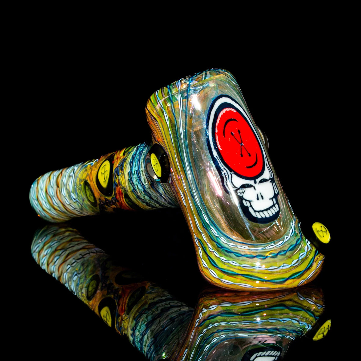 Colorful heady glass pipe with vibrant skull artwork and swirl patterns on a black background