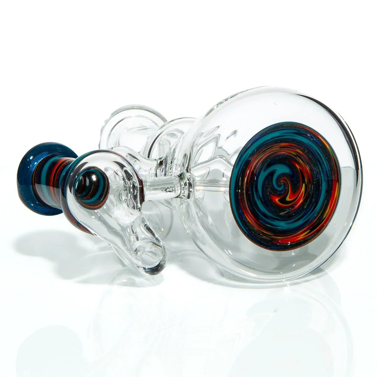 Clear glass pipe with colorful swirl design on the base and accents, resting on white surface.