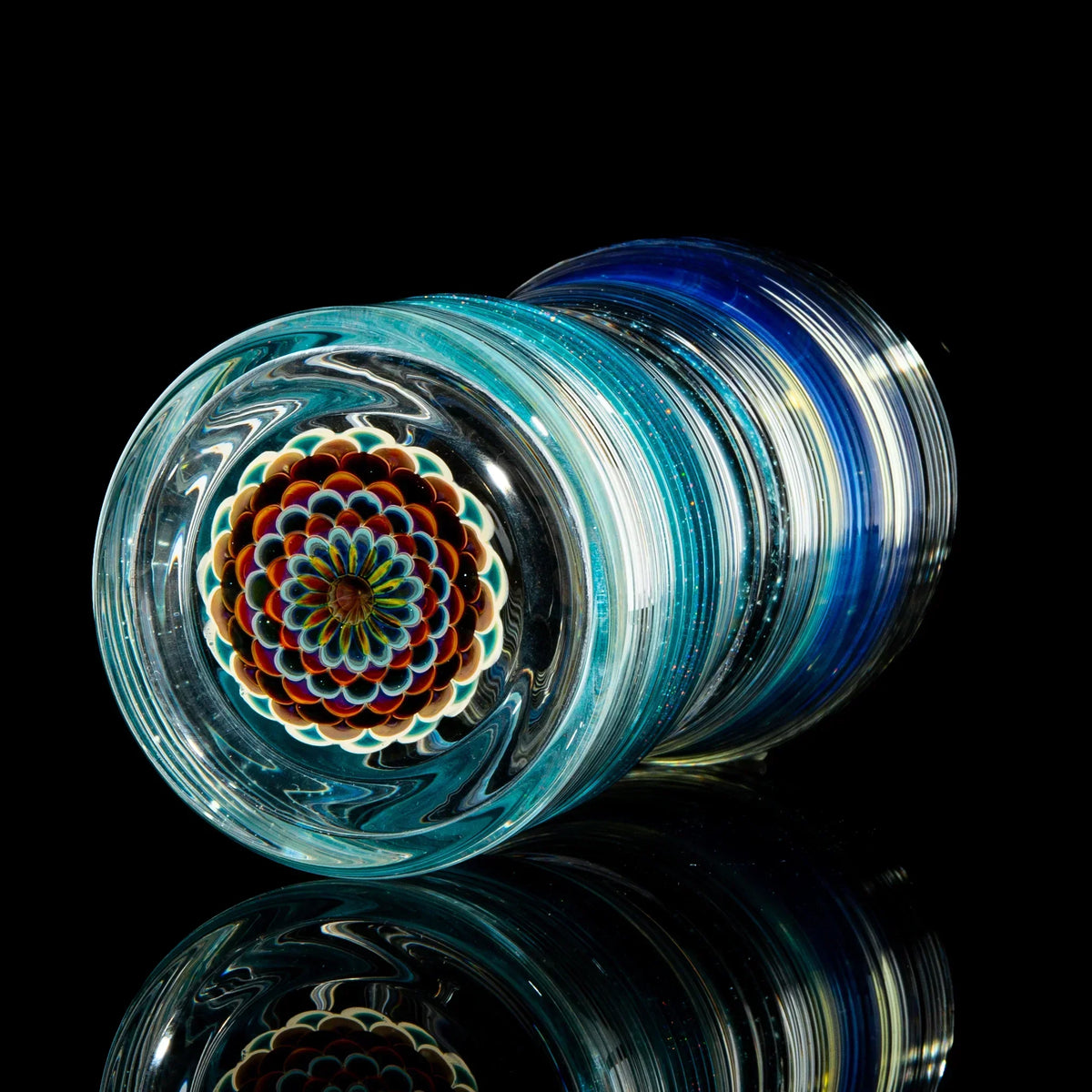 Hand-blown glass pint glass with teal and blue swirl patterns and intricate dot stack base