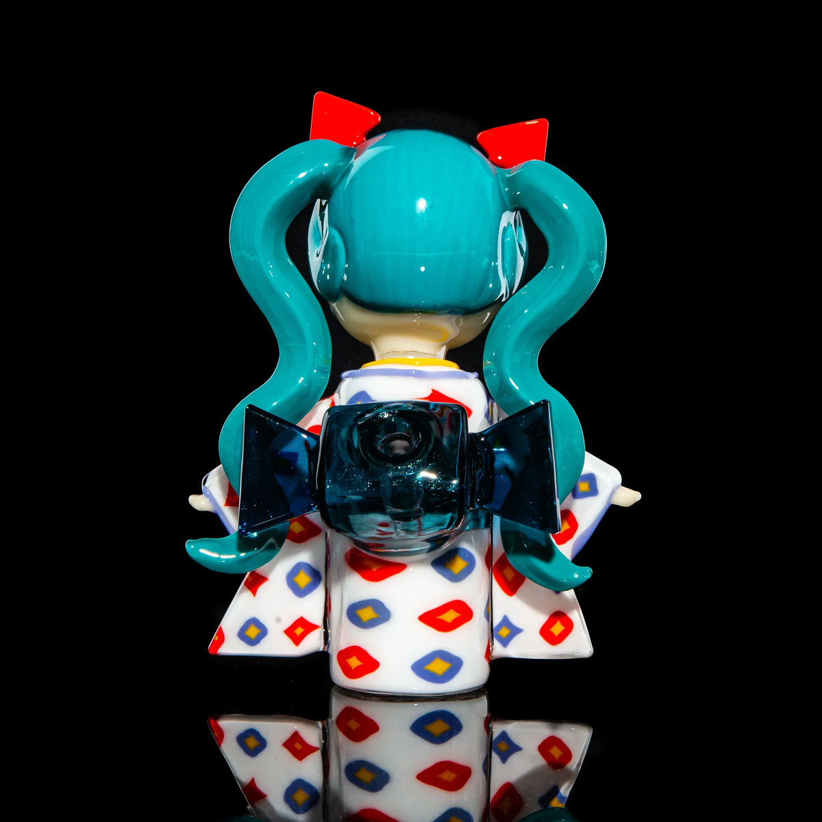 Glass art figure with teal pigtails and patterned kimono, displayed on black background