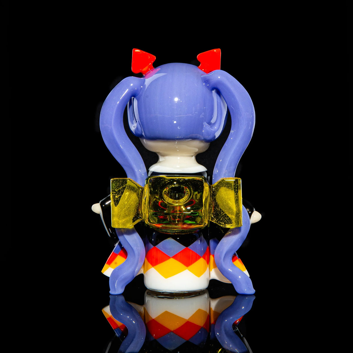Handcrafted glass art figure with purple pigtails, yellow bow, and colorful diamond dress