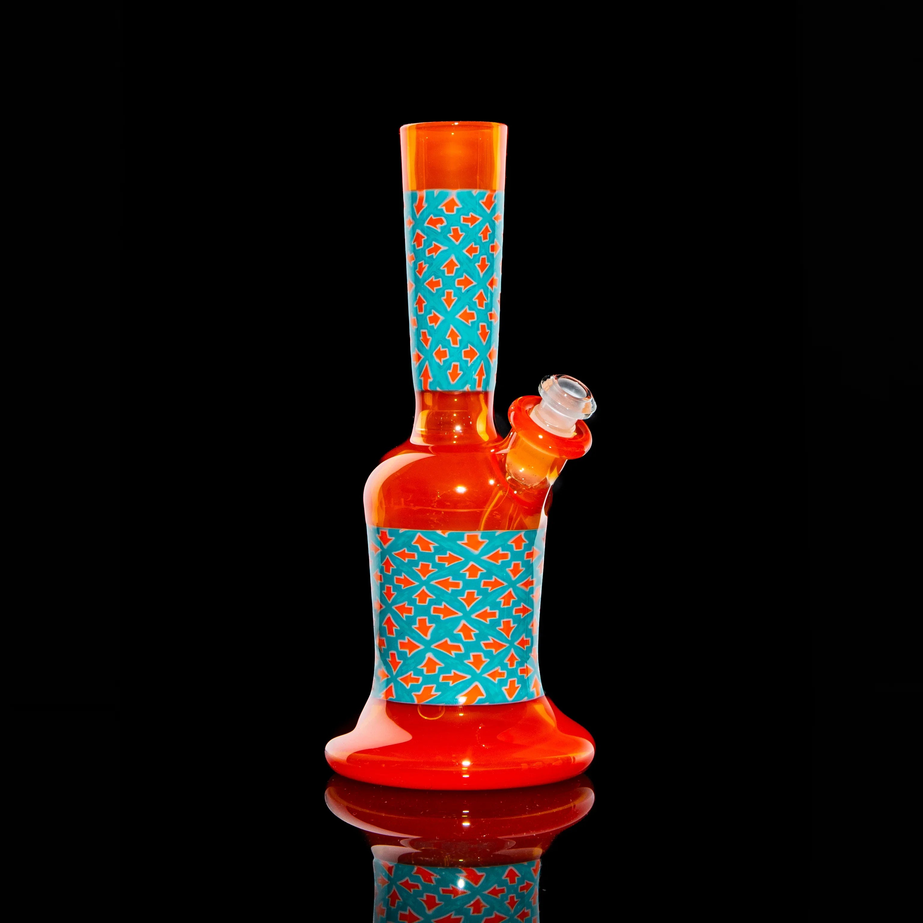 Red and orange glass water pipe with blue geometric pattern on black background