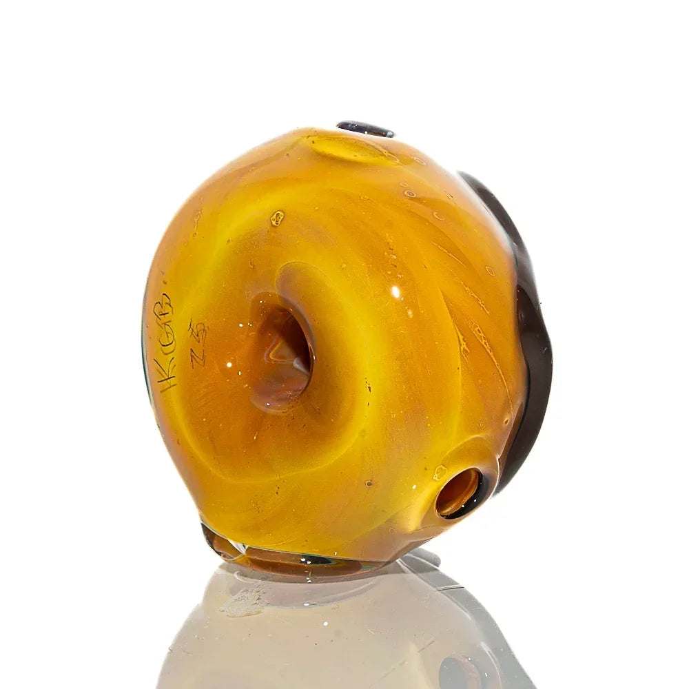 Glass hand pipe shaped like a chocolate frosted donut with half sprinkle design, isolated.