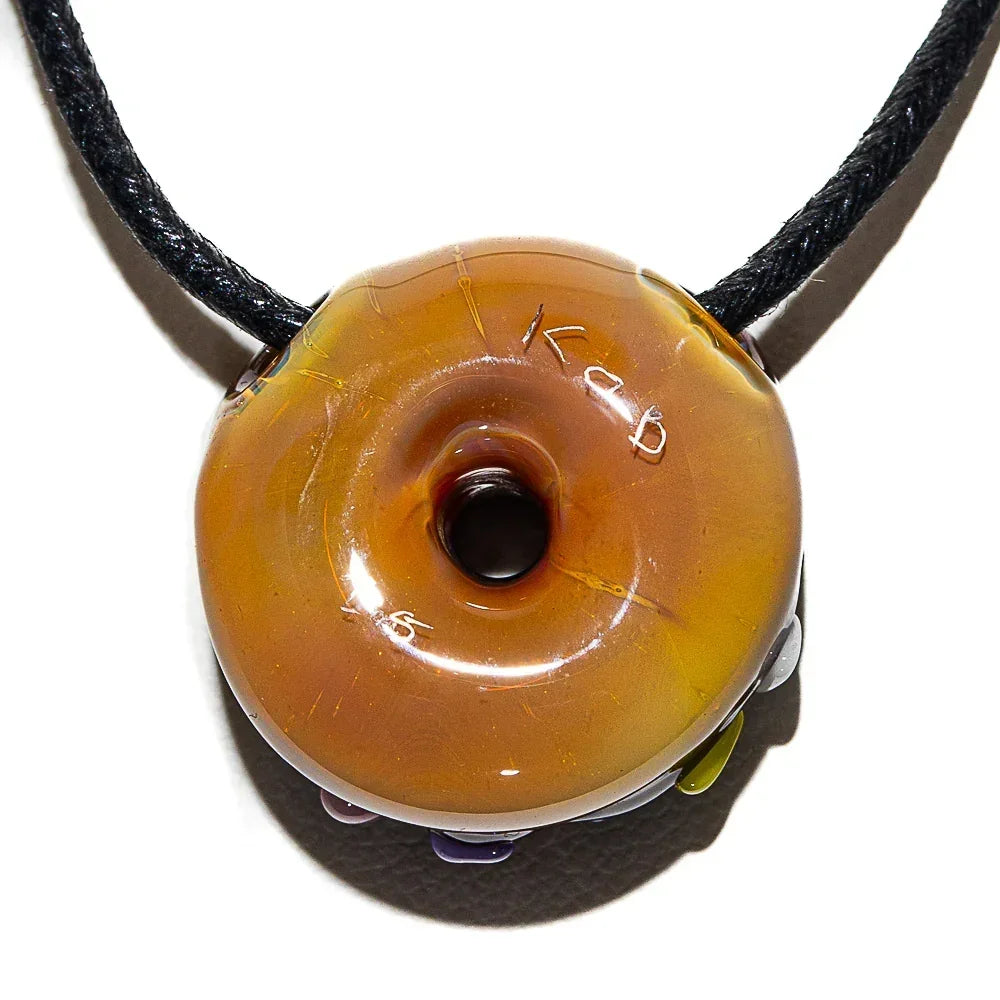 Glass donut pendant necklace with chocolate frosting and colorful sprinkles on a black cord