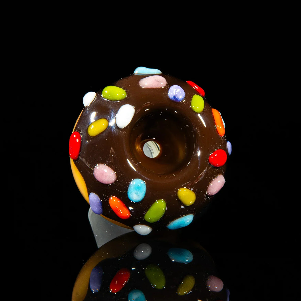 Glass bowl slide shaped like a chocolate donut with colorful sprinkles, black background
