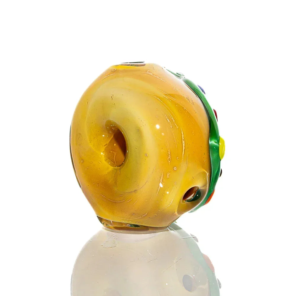 Yellow mini donut-shaped glass pipe with colorful frosted sprinkle accents on white background.