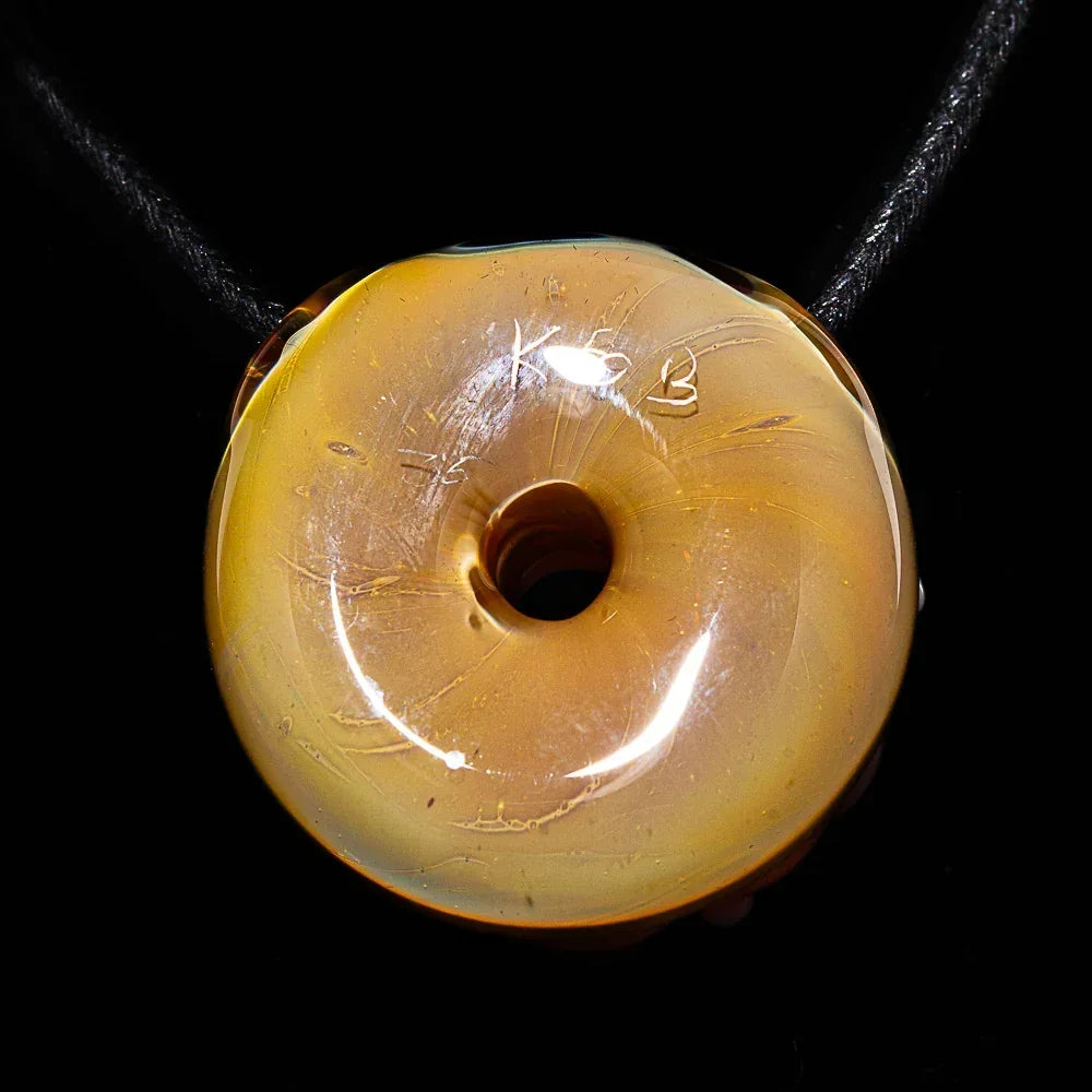 Handmade glass donut pendant with a smooth, glossy yellow finish on a black cord