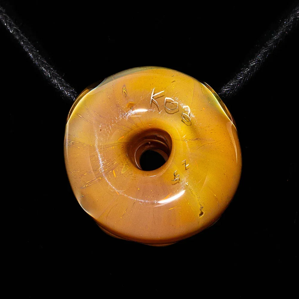 Handblown glass donut pendant with vanilla frosted blueberry drizzle design on black cord
