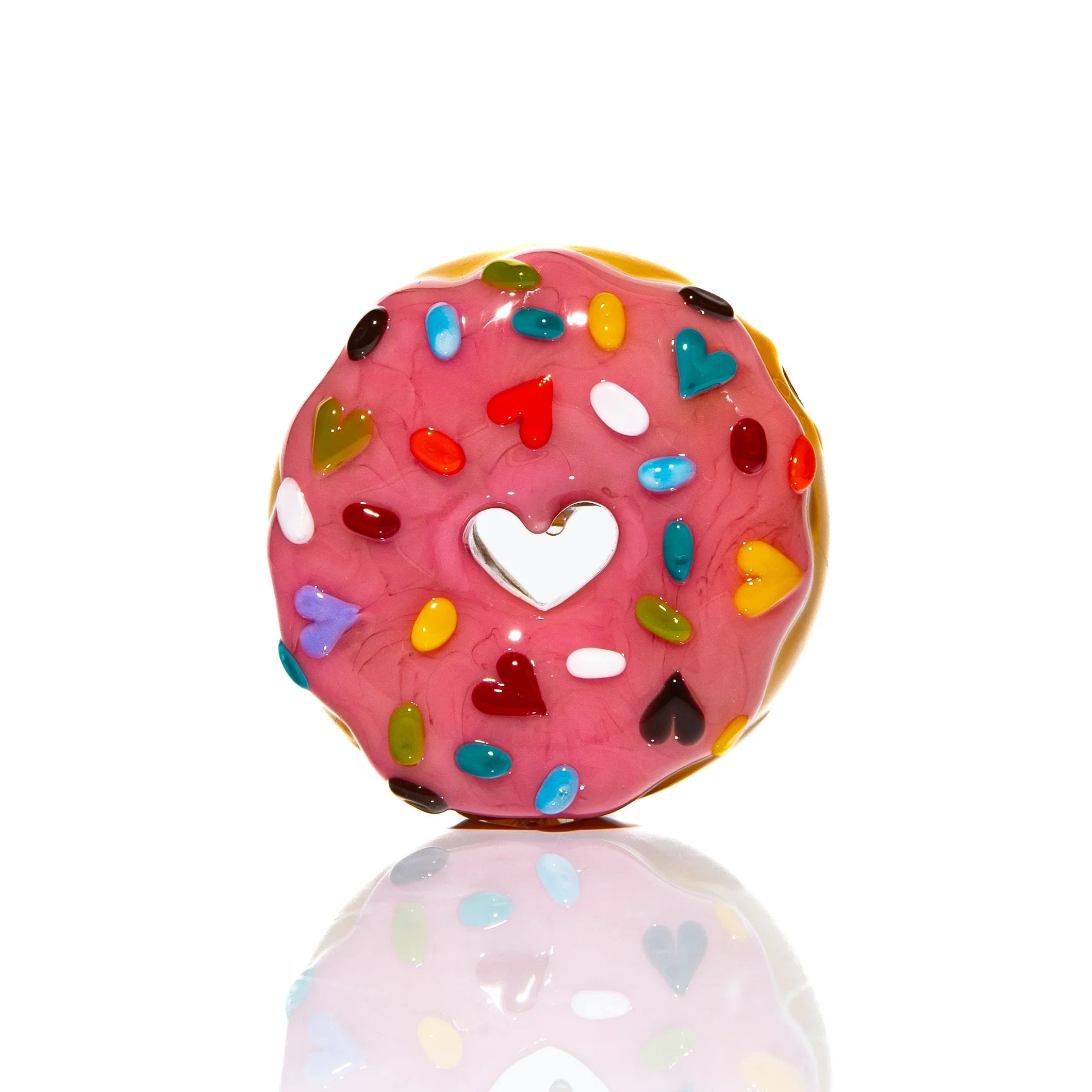 Pink glass donut pipe with heart and rainbow sprinkles design, isolated on white background.