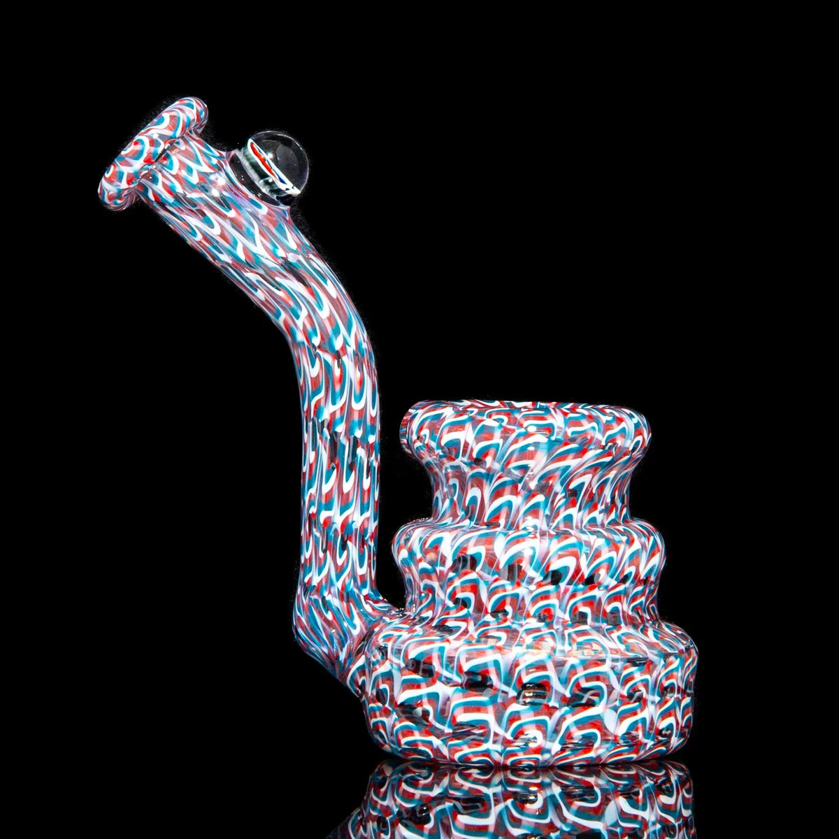 Colorful heady glass water pipe with red, white, and blue swirl patterns on black background